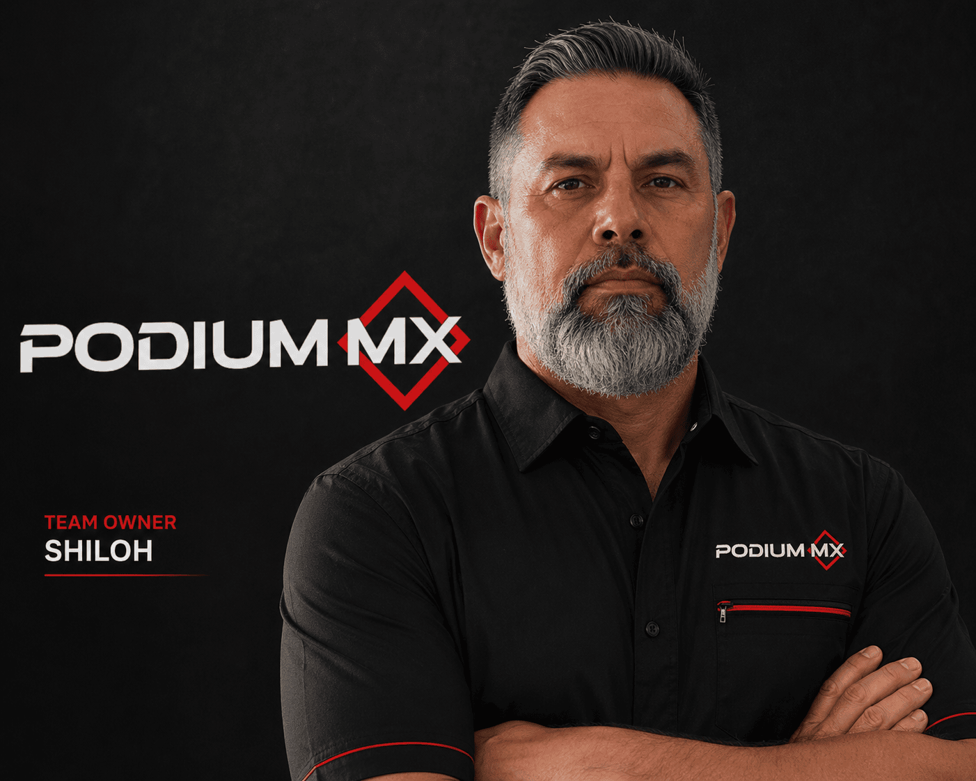 Professional man in black Podium MX shirt with crossed arms, dark background.