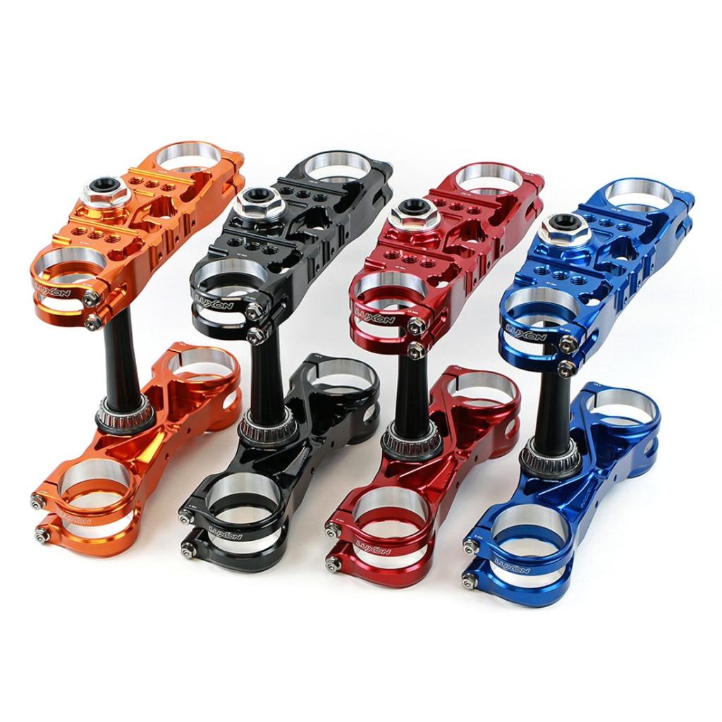 High-performance anodized motorcycle handlebar risers in orange, black, red, and blue.